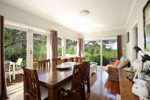 a dining room with a table and chairs and windows at The Nineteenth in Blackheath