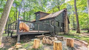 Una pequeña cabaña verde en el bosque con terraza. en The Biddle House by AvantStay Breathtaking Views, en Lake Harmony