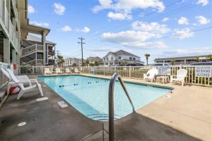 una piscina en un apartamento con sillas en North Myrtle's Kings View, 2nd Floor, Great Views!, en Myrtle Beach