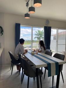 a man and woman sitting at a dining room table at VOGUE D, a private inn with a panoramic view - Vacation STAY 86199v in Isumi