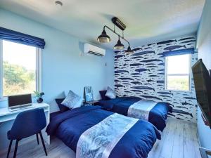 a bedroom with two beds and a stone wall at VOGUE D, a private inn with a panoramic view - Vacation STAY 86199v in Isumi