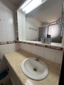 Departamento frente al mar في تومي: حمام مزود بحوض ومِرآة