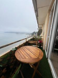 Departamento frente al mar في تومي: طاولة وكراسي على شرفة مطلة على المحيط