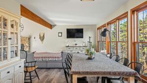 Lakers Pointe by AvantStay Lakefront Private Peninsula Hot Tub Game Room في Long Pond: غرفة طعام مع طاولة وكراسي