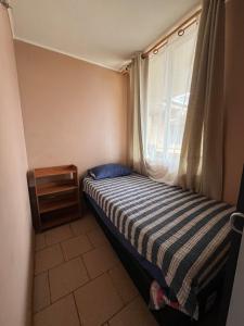 Departamento frente al mar في تومي: غرفة نوم صغيرة بها سرير ونافذة