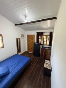 a bedroom with a blue bed and a kitchen at Kit net great price in São Sebastião +39 photos