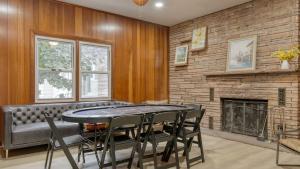 a dining room with a table and chairs and a fireplace at Game Farm Villa by AvantStay 10BDR Private Pond Spa Pool Family-Friendly in Catskill