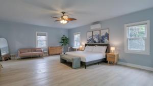 a bedroom with a bed and a couch and windows at Game Farm Villa by AvantStay 10BDR Private Pond Spa Pool Family-Friendly in Catskill +53 photos