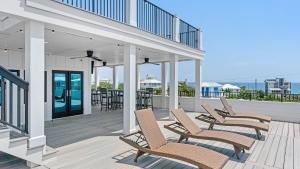 a row of chairs on a deck with a table at All Decked Out Seagrove by AvantStay Priv PoolHot Tub Ocean Views in Santa Rosa Beach