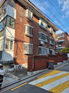 a red brick building on a city street at Stay179 Guesthouse - Female only in Seoul
