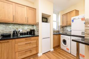 een keuken met een witte koelkast, een wasmachine en een droger bij Heart of Looe Apartment in Looe +4 foto's