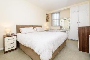 een slaapkamer met een groot bed en een wastafel bij Heart of Looe Apartment in Looe