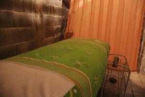 a bed in a room with a green blanket at Chrisma Bed and Breakfast in Tomohon
