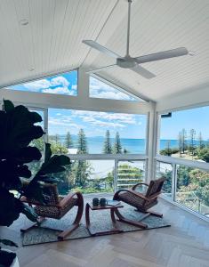a living room with chairs and a ceiling fan at Barbara's Beach House in Hallidays Point