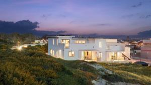 a white house on top of a hill at night at Oceanfront 2BR Rooftop Deck Beach Access Strand Way B in Oceano