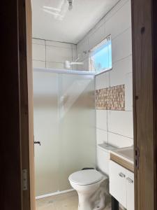 a white bathroom with a toilet and a sink at Park e Mar Studio quarto 1 in Penha +6 photos