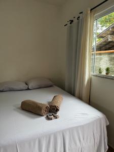 a bed with a towel and a window at Park e Mar Studio quarto 1 in Penha