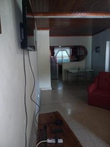 sala de estar con TV y sofá rojo en Hospedaje carvajal, en David