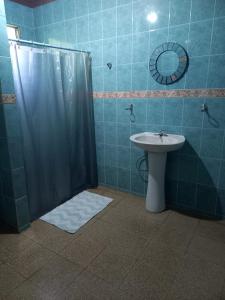 Un baño con lavabo y ducha con cortina de ducha. en Hospedaje carvajal, en David