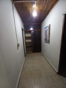 Un pasillo con una puerta y suelo de baldosas. en Hospedaje carvajal, en David