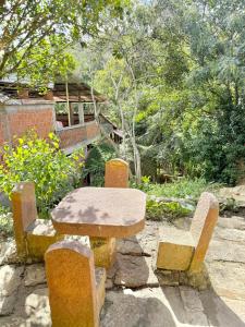 a stone table and chairs in front of a building at Cabaña frente al Río-Curití-San Gil in Curití