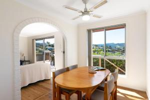een eetkamer met een tafel en een groot raam bij Ziggy's Place in Gerringong