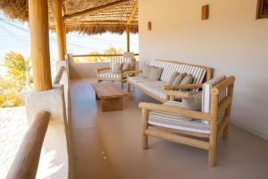 a living room with couches and chairs and a table at Villa Vento in Camocim