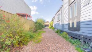 EpsomNouveau Home的建筑物旁边两栋建筑物之间的一条碎石小路