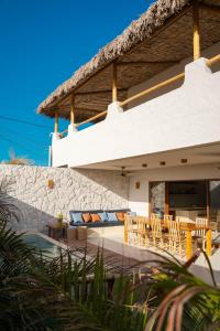 a villa with a patio with chairs and a table at Villa Vento in Camocim