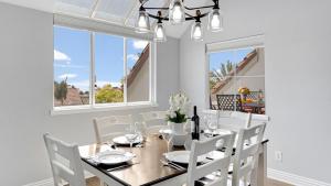 a dining room with a table and chairs and windows at Encantamar Escape by AvantStay Prime Location Community Amenities in Dana Point