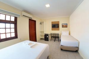 Un dormitorio con dos camas y una mesa y sillas. en Vale Confort Hotel, en Petrolina 25 fotos más
