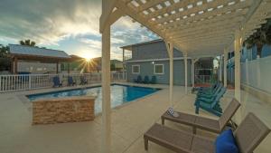 una casa con piscina y un patio con bancos en Chic 2BR Coastal Condo Shared Pool Near the Beach Costa Bahia 103, en Port Aransas