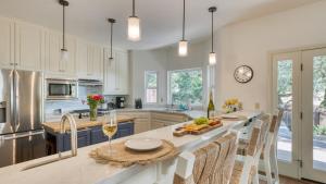 a kitchen with white cabinets and a table with glasses of wine at Casa Osito by AvantStay Pool Hot Tub Outdoor Dining Minutes from Sonoma Plaza in Sonoma