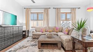 Red Fish Blue Mountain by AvantStay Private Beach Gulf View في شاطئ سانتا روزا: غرفة معيشة بها أريكة وطاولة