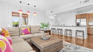 Red Fish Blue Mountain by AvantStay Private Beach Gulf View في شاطئ سانتا روزا: غرفة معيشة مع أريكة ومطبخ