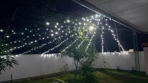 a string of lights over a white fence at night at The Grace Cottage - Negombo in Dagonna
