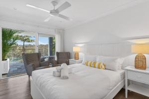 Un dormitorio blanco con una cama y un balcón. en Garigal Studio 1br Unit with Pool Access, en Forestville