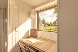 RuatapuにあるRimu View 3 by Tiny Awayのテーブルとノートパソコン付きの窓が備わる客室です。