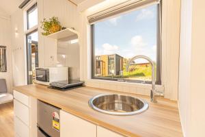 RuatapuにあるRimu View 3 by Tiny Awayのシンクと大きな窓のあるキッチン +15枚の写真