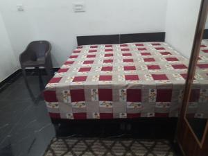 a bed with a quilt on it in a room at DS Villa in Noida