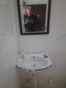 a man taking a picture of a bathroom sink at DS Villa in Noida +2 photos