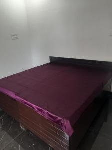 a bed with a purple sheet on top of it at DS Villa in Noida