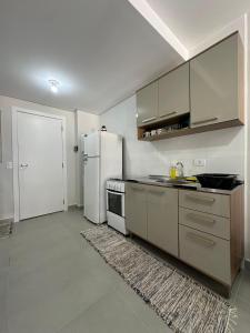 een keuken met een witte koelkast en een fornuis bij Bela Vista in Matinhos +16 foto's