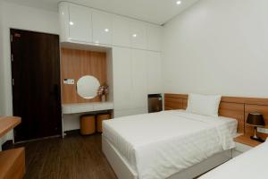 Un dormitorio con una cama blanca y un espejo. en TD Apartment, en Hai Phong