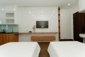 Dos camas en una habitación con un televisor en la pared. en TD Apartment, en Hai Phong 20 fotos más