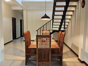 uma sala de jantar com uma mesa e cadeiras e uma escadaria em Kandy Villa em Kandy mais 6 fotografias