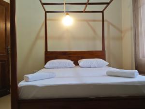 uma cama com duas almofadas e uma luz em cima em Kandy Villa em Kandy
