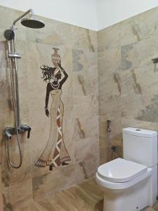 uma casa de banho com um mural de uma mulher na parede em Kandy Villa em Kandy
