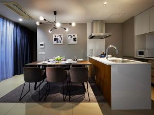 Minn Umeda North في أوساكا: مطبخ مع طاولة وكراسي ومغسلة