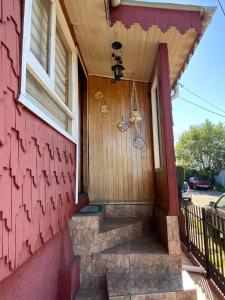 porta da frente de uma casa com uma casa vermelha em Ruperta Home em Achao mais 14 fotografias